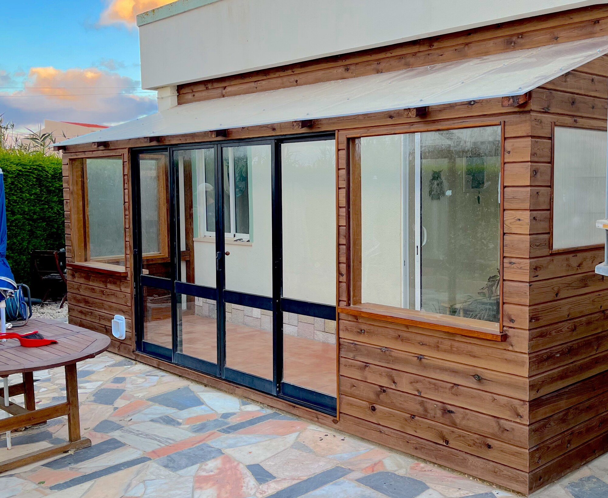 Exterior of a handmade timber conservatory with broad glazed doors and windows
