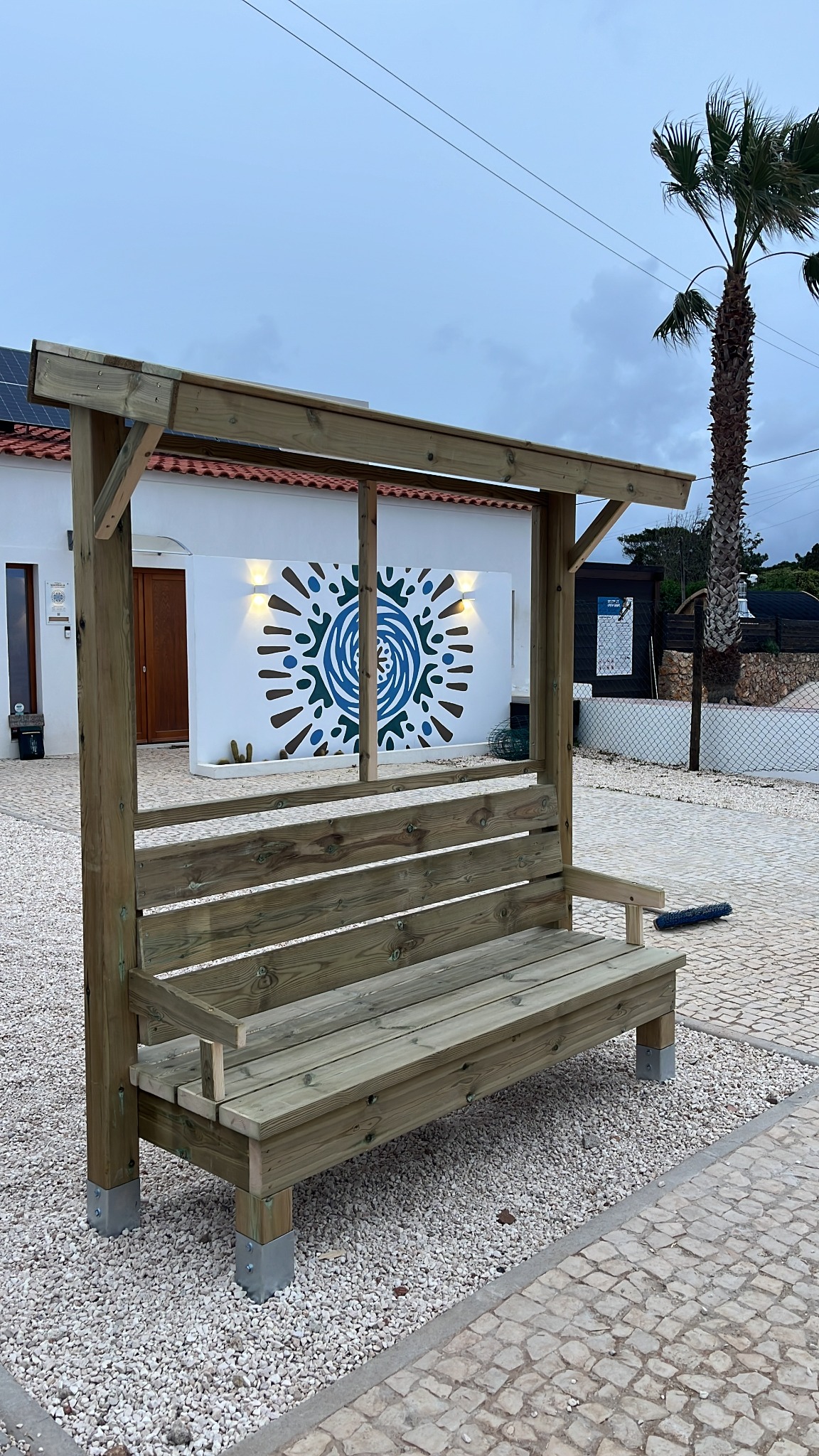 Timber garden bench built beneath its own simple shelter